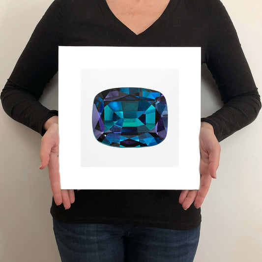 A giclee fine art print of an alexandrite gemstone on a very pale stone background. This image illustrates the print size.