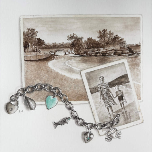 Bracelet with charms on a background of a sepia photograph of Balmoral Beach and a photo of a family.