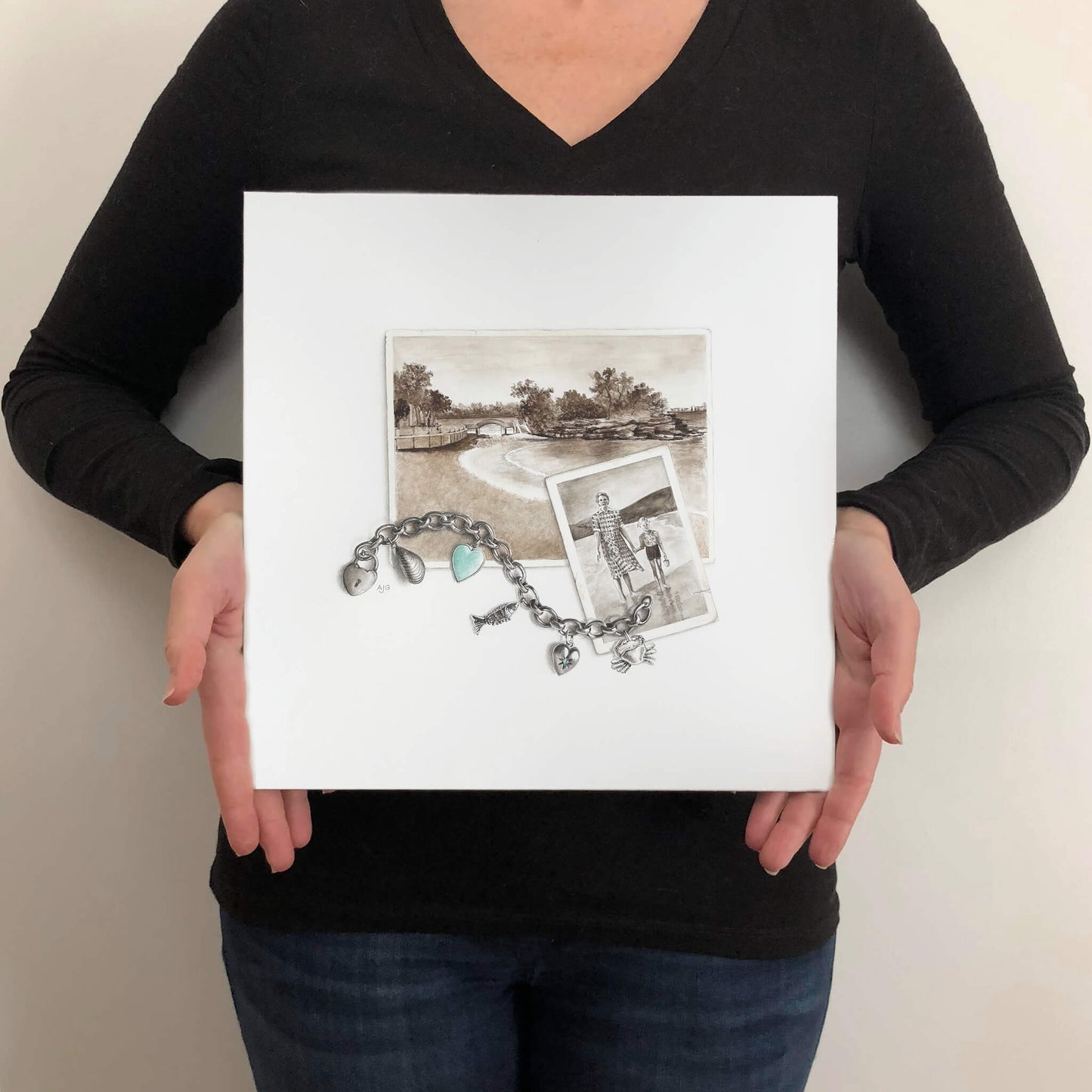 Person holding a square painting of a bracelet and photo on a neutral background