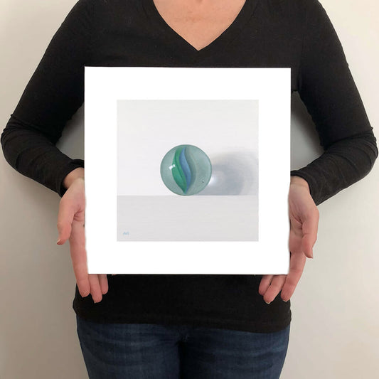A giclée fine art print on paper of a toy marble on a light grey background. This image illustrates the print size.