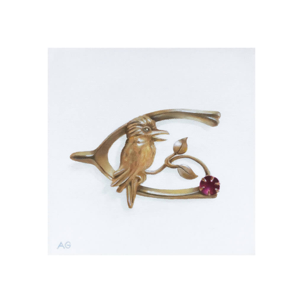 A giclée fine art print of an antique Australian gold and ruby kookaburra brooch on a pale stone background.