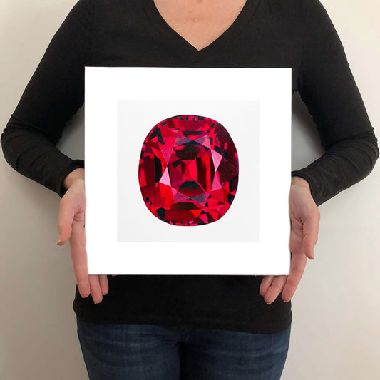 A giclée fine art print of a ruby gemstone on a light stone background. This image illustrates the print size.