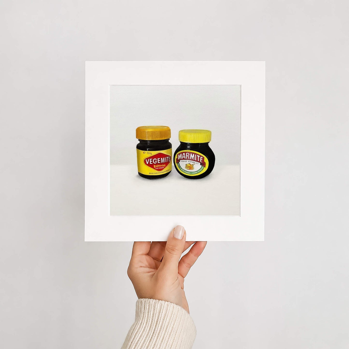 An art print of two jars of Vegemite and Marmite held up against a white background