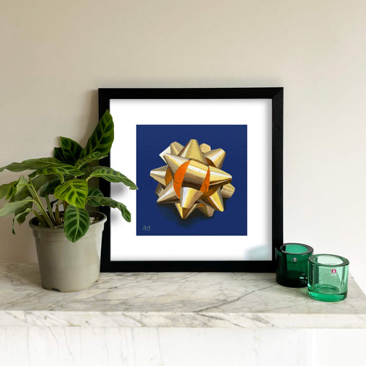 A giclée fine art print of a gold foil gift bow on a cobalt blue background