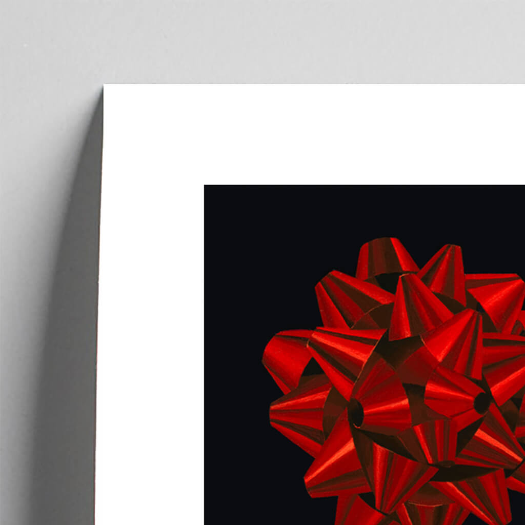 Fine art print of a red foil gift bow against black background by Amanda Gosse artist detail