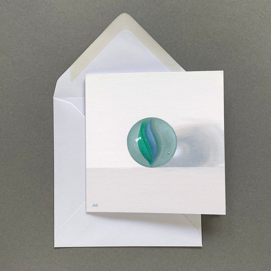 A square greetings card picturing a green and blue glass cats eye marble painting by Amanda Gosse