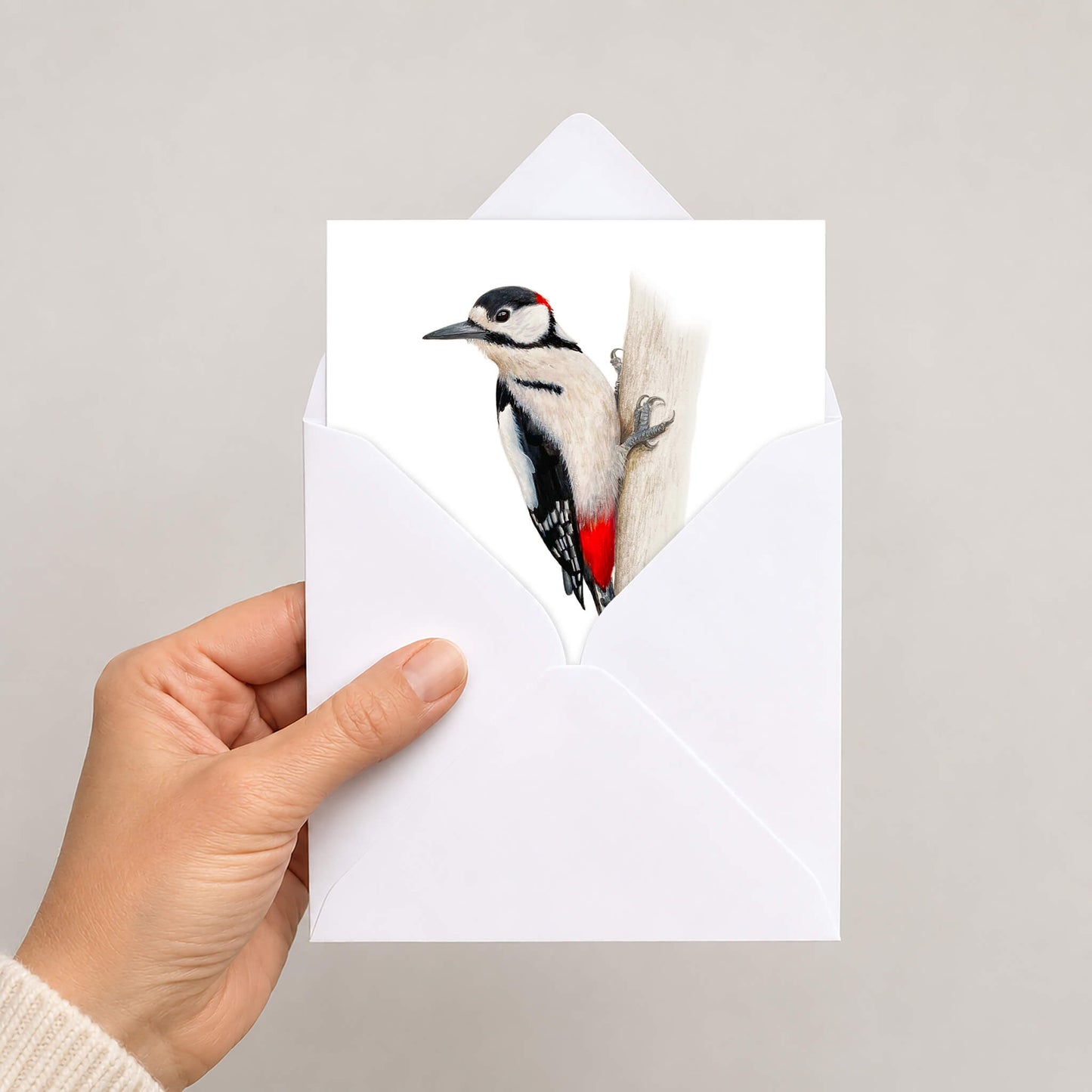 Greetings card in envelope held by hand