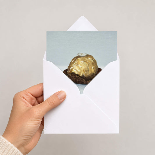 An Italian chocolate greetings card in white envelope held by hand