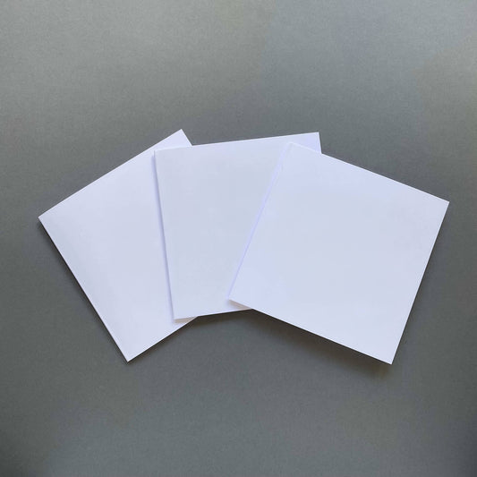 Three blank square greetings cards displayed in fan position on a grey background.