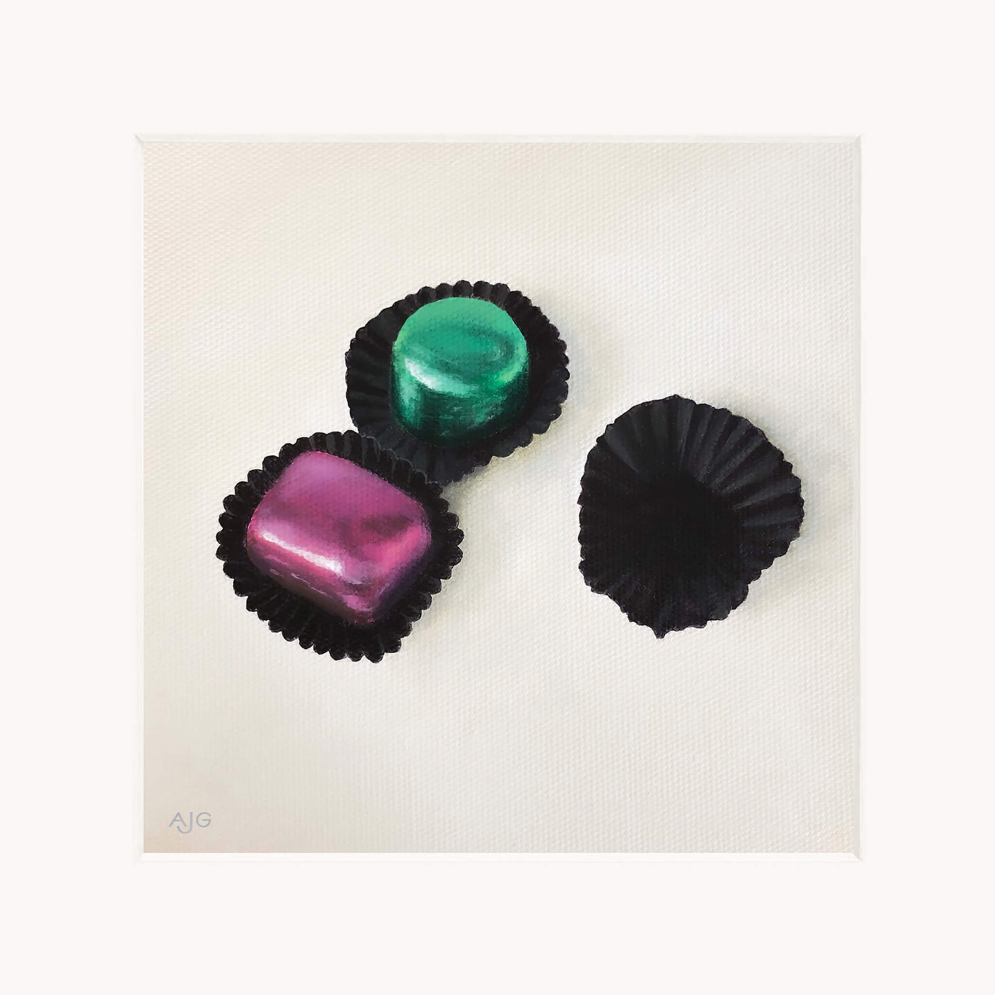 Giclée print in mount of three colourful chocolates in black casings on a white background