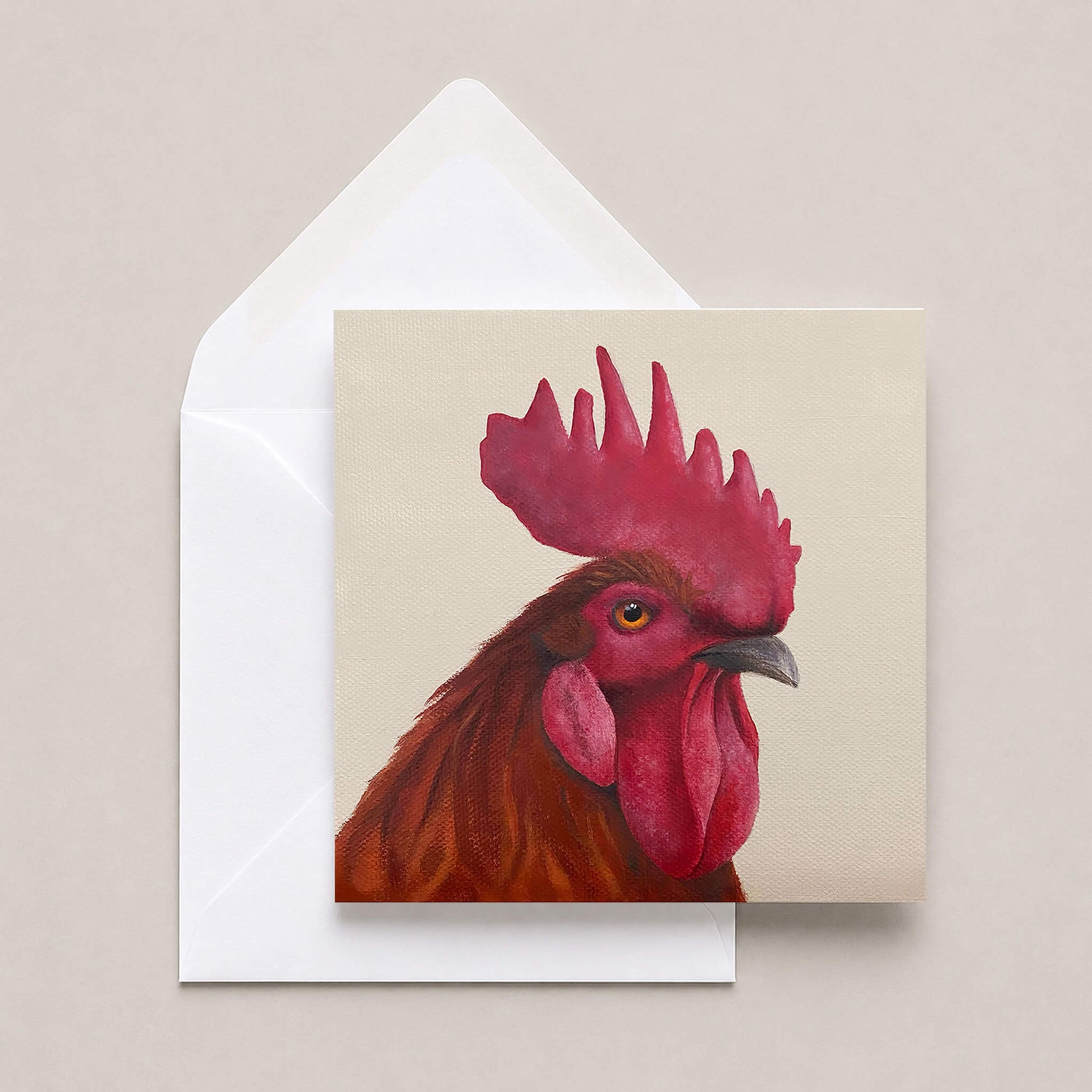 Greetings card featuring a cockerel portrait with a white envelope on a neutral background