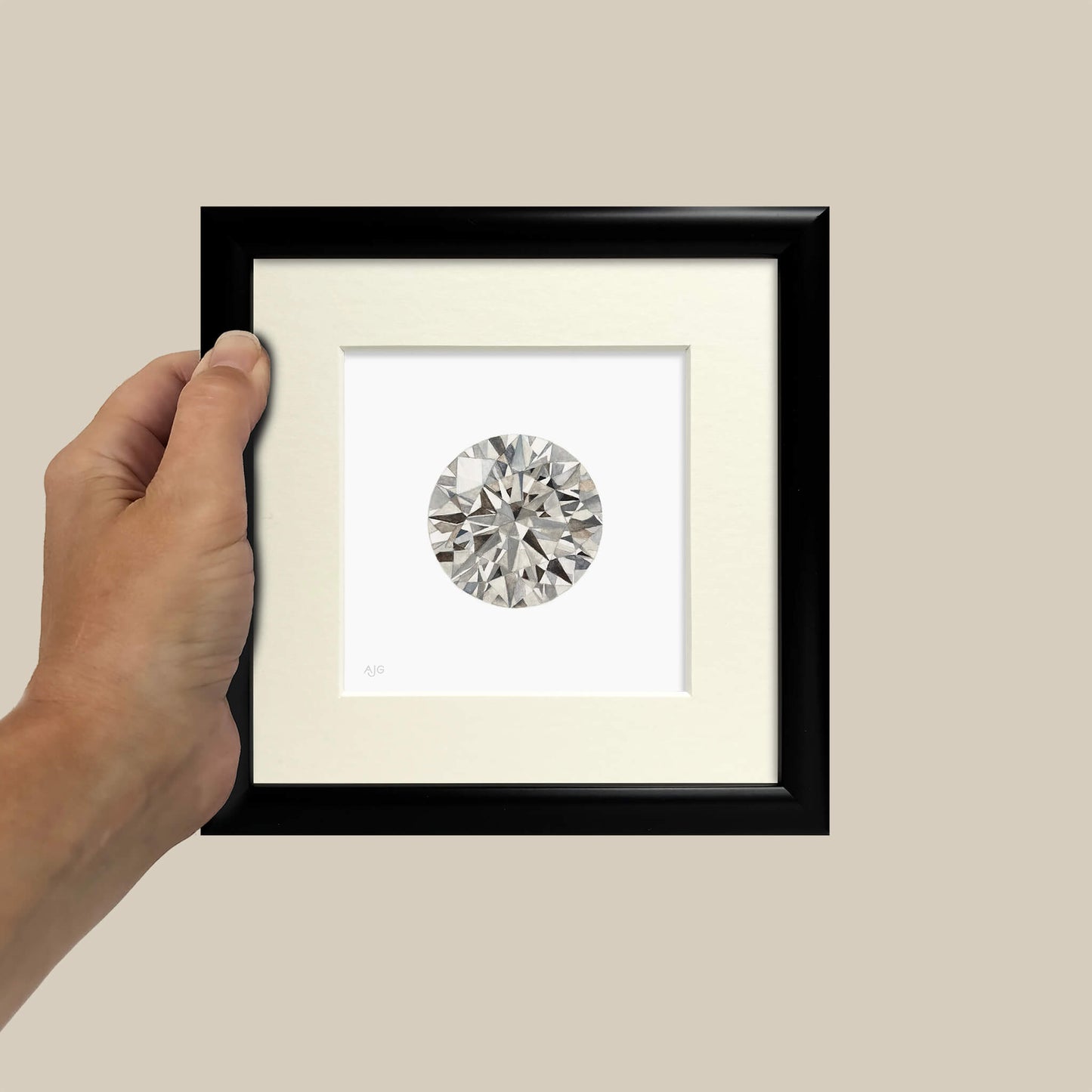 Framed diamond held by a hand against a beige background