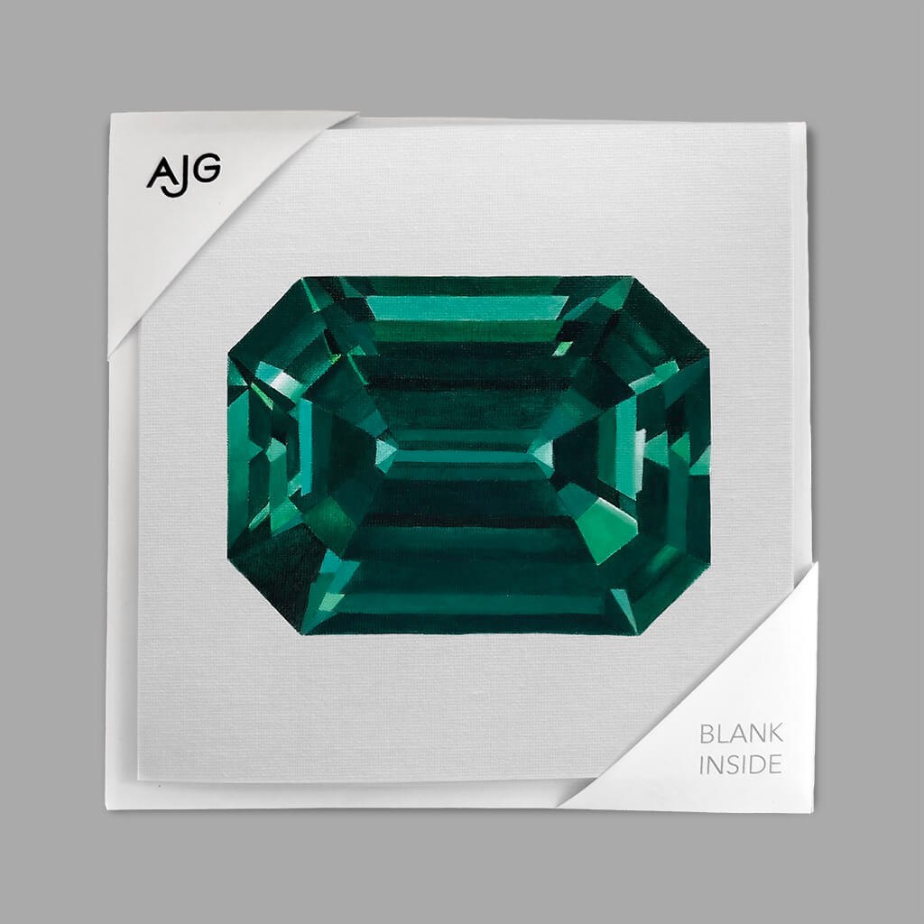 Green gemstone on a white card with 'AJG' branding