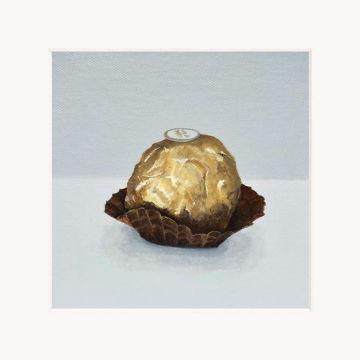 Gold-wrapped chocolate in a brown case on a light gray background