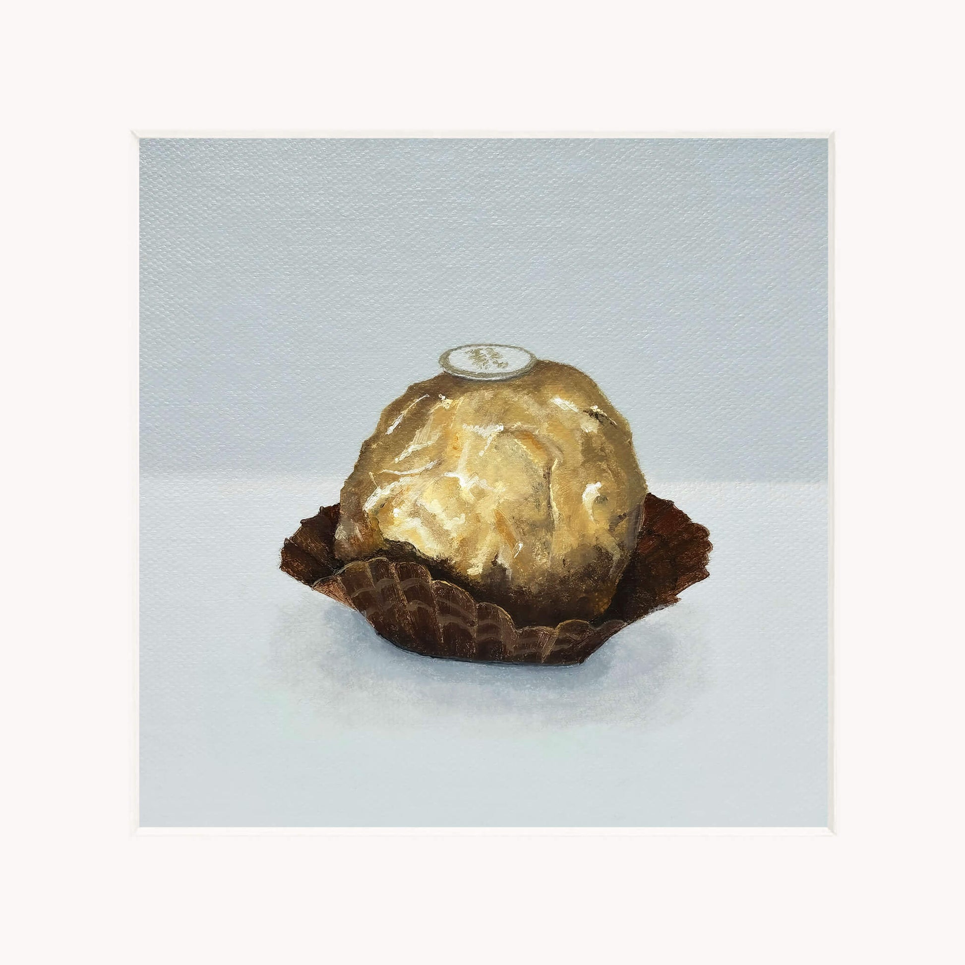 Gold-wrapped chocolate in a brown case on a light gray background