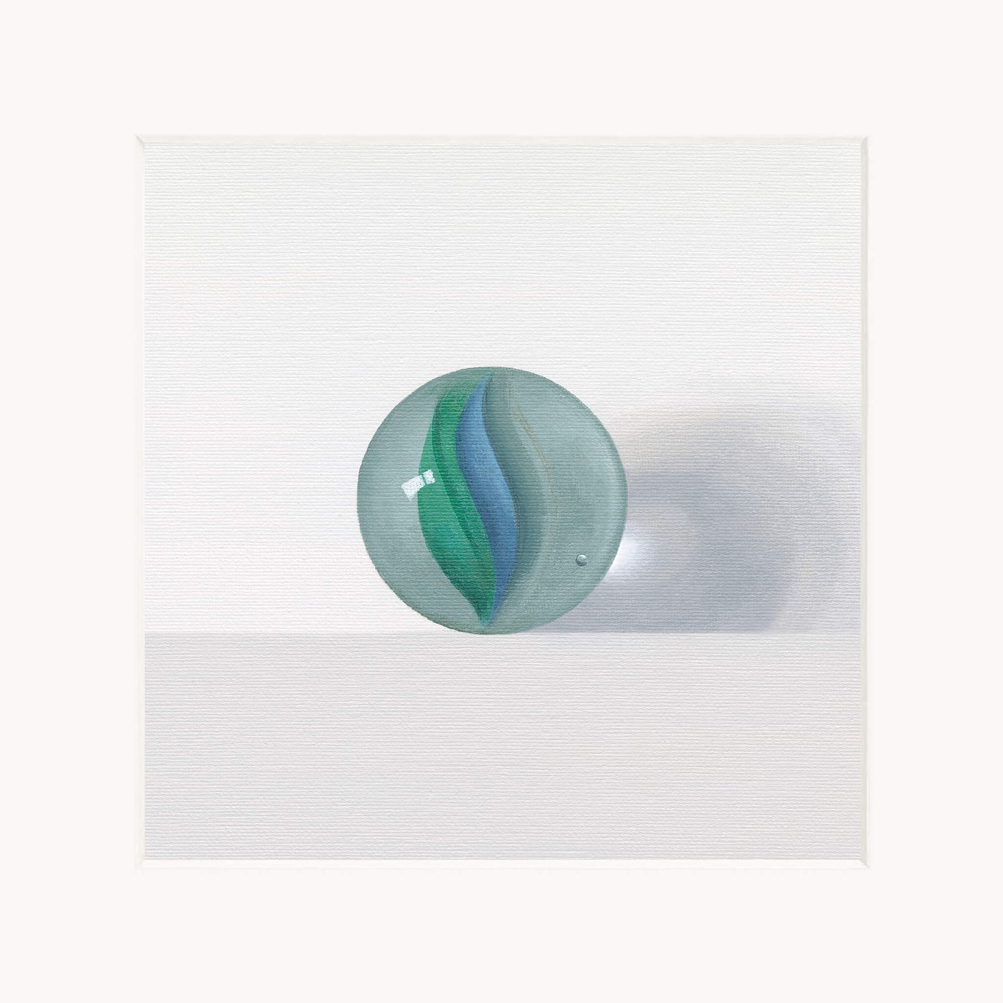 Mounted art print of a green and blue glass marble on a white background