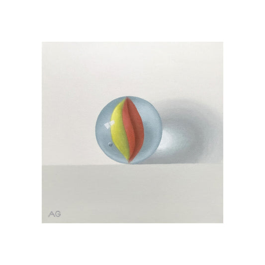 A giclée fine art print of a red and yellow glass marble, against a pale neutral colour background.