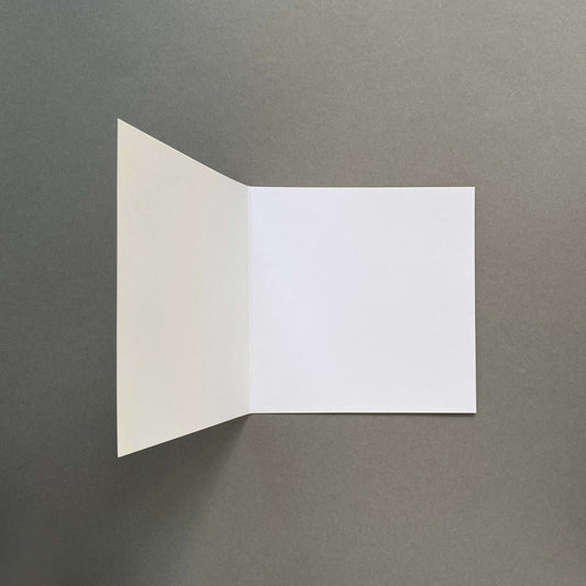 Inside of an open square blank greetings card on a grey background