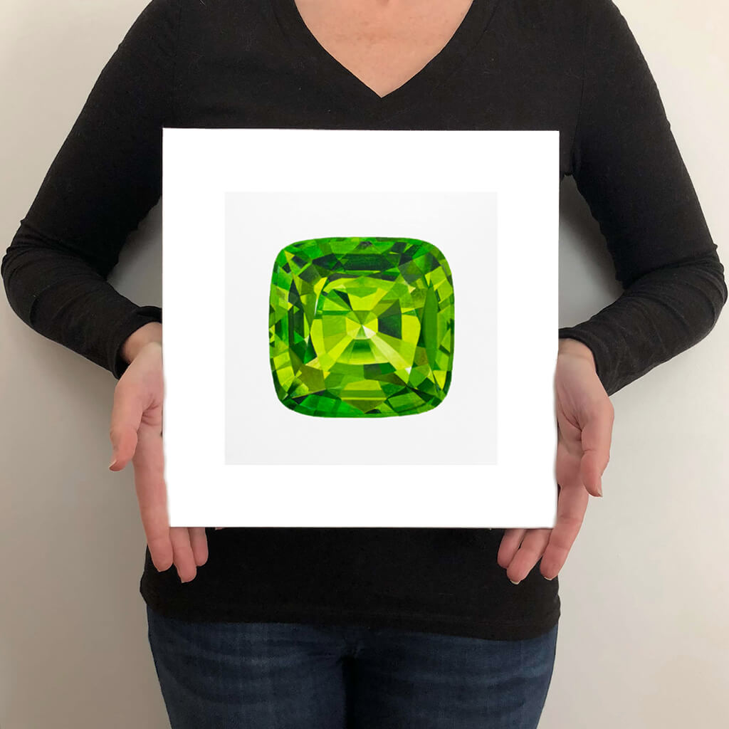 A giclée fine art print of a Peridot gemstone on a light stone background. This image illustrates the print size.