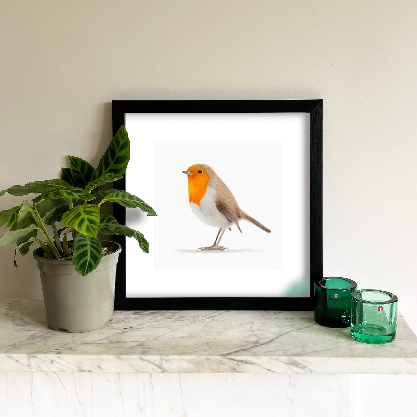 A bird giclee fine art print on paper of a robin on a light grey background. Image shows the print framed and in a room setting.