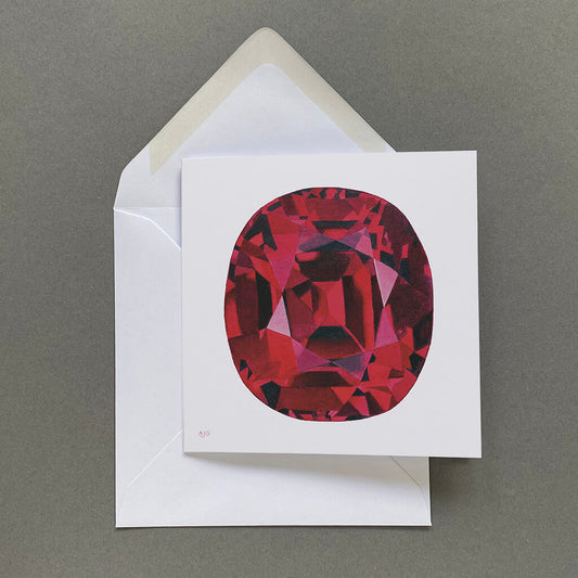 Card with a red gemstone design on a white envelope against a pale grey background