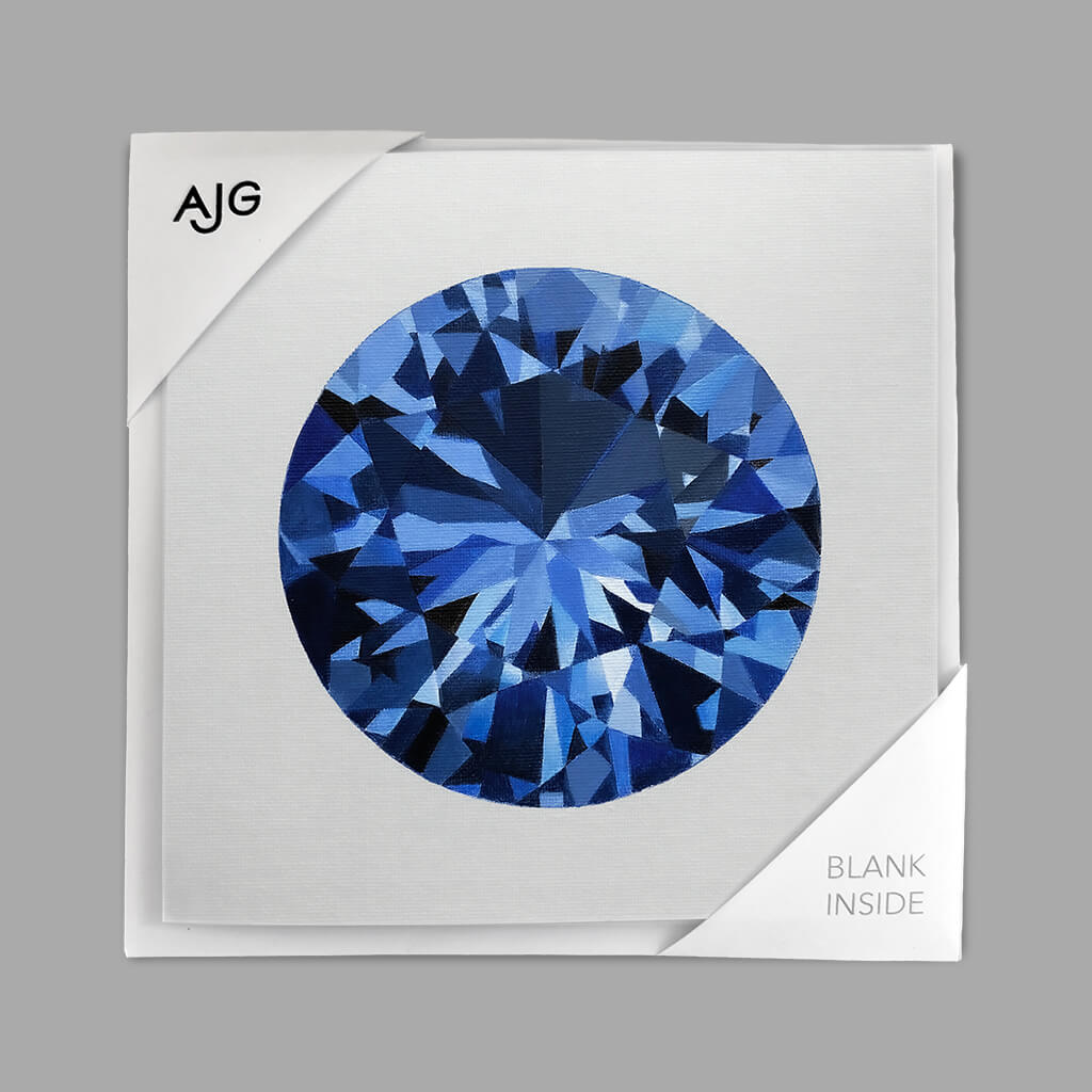 Greetings card with a blue sapphire gemstone design on a pale grey background with AJG holder