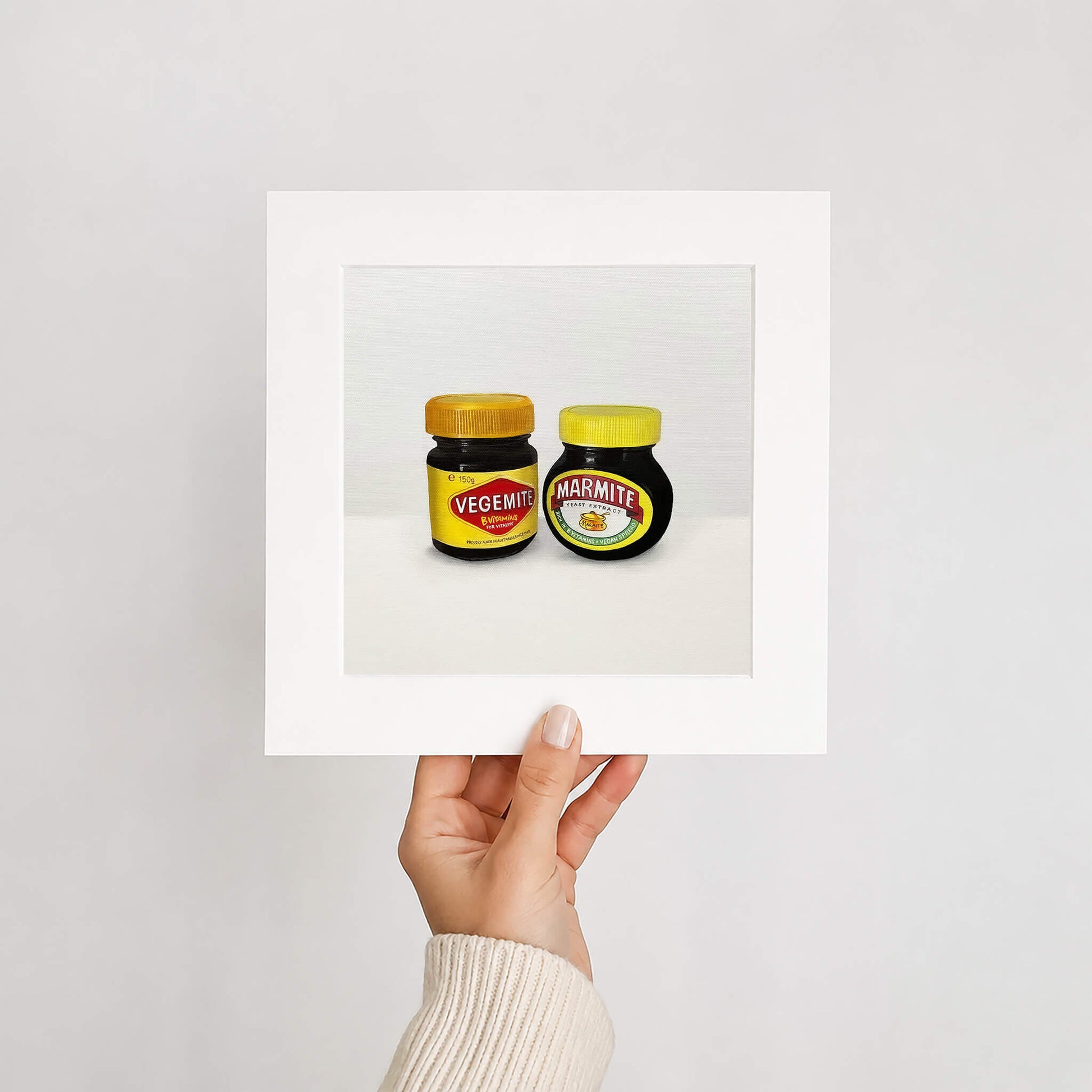 An art print of two jars of Vegemite and Marmite held up against a white background