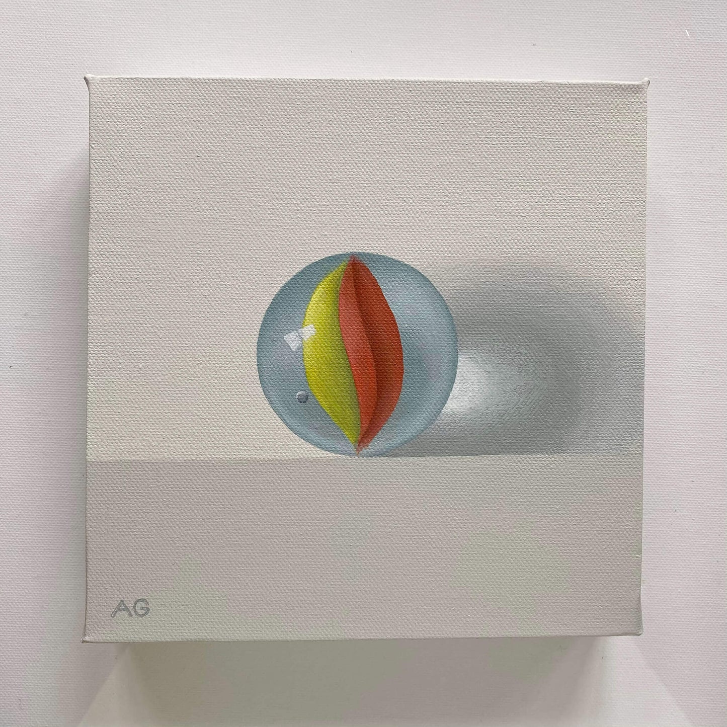 original realism acrylic painting of a yellow and red retro glass marble toy painted by Amanda Gosse